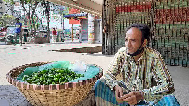 করোনাভাইরাসের প্রভাবে বাঁশের টুকরিতে মরিচ নিয়ে বসে আছেন পেশা পাল্টানো বজলুর রহমান। চাষাঢ়া, নারায়ণগঞ্জ, ১ এপ্রিল। ছবি: গোলাম রাব্বানী