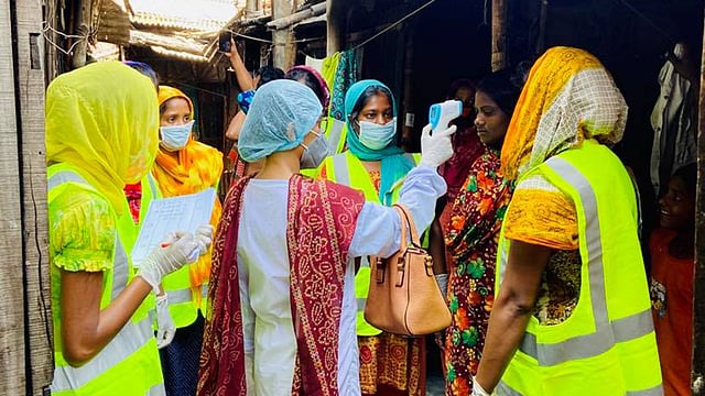স্বেচ্ছাসেবক নাদিয়া আফরিন অন্য নারীদের সঙ্গে বস্তির মানুষের সুরক্ষায় কাজ করছেন। ছবি: সংগৃহীত