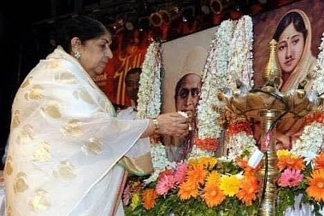 বাবার প্রতিকৃতিতে ফুল দিয়ে শ্রদ্ধা জানাচ্ছেন লতা। ছবি: টুইটার