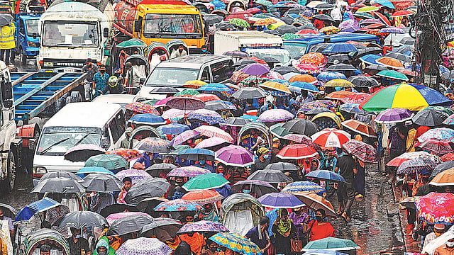 অর্থনীতির চাকা সচল রাখতে করোনাভাইরাস সংক্রমণ ঝুঁকির মধ্যেই কাজ শুরু হয়ে গেছে তৈরি পোশাক কারখানাগুলোতে। এক মাস ছুটির পর ঝুঁকি নিয়েই কাজে যোগ দিয়েছেন শ্রমিকেরা। এত দিন শহরের তেমন শোরগোল না থাকলেও কাল চট্টগ্রাম নগরের ইপিজেড এলাকা ফিরে আসে পুরোনো চেহারায়। সারা দিন কাজ শেষে বৃষ্টিতে ছাতা মাথায় বাড়ি ফিরছেন শ্রমিকেরা। গতকাল বিকেল চারটায়। ছবি: জুয়েল শীল