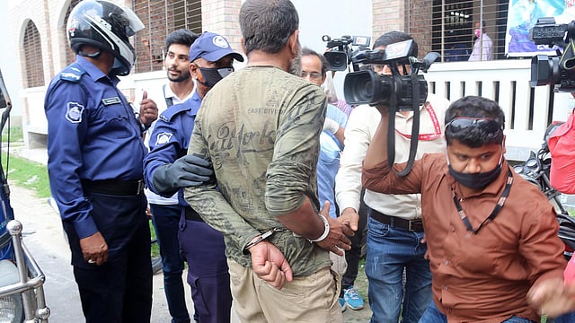 ফটোসাংবাদিক শফিকুল ইসলাম কাজলকে হাতকড়া পরিয়ে নিয়ে যায় পুলিশ। প্রথম আলো ফাইল ছবি
