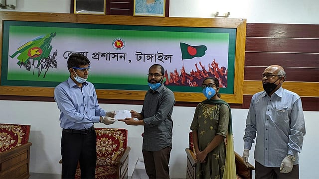 টাঙ্গাইলের ভূঞাপুর উপজেলার দুই ভাই–বোন ইশরাক ও মিথিলা তাঁদের জমানো বৃত্তির টাকা টাঙ্গাইলের জেলা প্রশাসক মো. শহীদুল ইসলামের মাধ্যমে প্রধানমন্ত্রীর ত্রাণ তহবিলে প্রদান করেন। আজ বৃহস্পতিবার টাঙ্গাইল জেলা প্রশাসকের কার্যালয়ে। ছবি: প্রথম আলো
