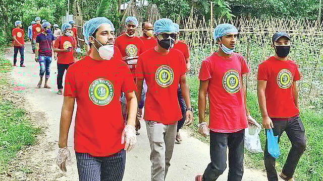 হিউম্যান ওয়েলফেয়ার অ্যাসোসিয়েশনের কর্মীরা শাকসবজির বীজ ঘরে ঘরে পৌঁছে দিচ্ছেন। ২০ মে মৌলভীবাজার সদরের কামালপুরে। ছবি: প্রথম আলো