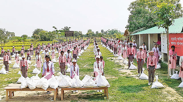 প্রথম আলো ট্রাস্টের উদ্যোগে ও সামিট গ্রুপের সহায়তায় রাজশাহীর গোদাগাড়ী উপজেলার মোহনপুর ইউনিয়নে বাবুডাইং আদিবাসী আলোর পাঠশালার শিক্ষার্থীদের মধ্যে খাদ্যসামগ্রী বিতরণ করা হয়। রোববার বিদ্যালয় প্রাঙ্গণে। ছবি: প্রথম আলো