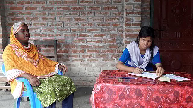 বাড়িতে বসে মায়ের উপস্থিতিতে পরীক্ষা দিচ্ছে দশম শ্রেণির এক ছাত্রী। পঞ্চগড়ের আটোয়ারী উপজেলার রাধানগর এলাকায়। ছবি: প্রথম আলো