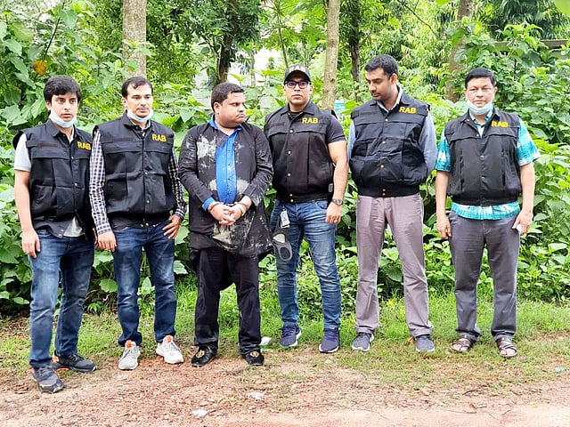র্যাবের হাতে গ্রেপ্তার রিজেন্ট হাসপাতাল মামলার প্রধান পলাতক আসামি ও রিজেন্ট গ্রুপের চেয়ারম্যান মো. সাহেদ (হাতকড়া লাগানো)। ছবি: র্যাবের সৌজন্যে।