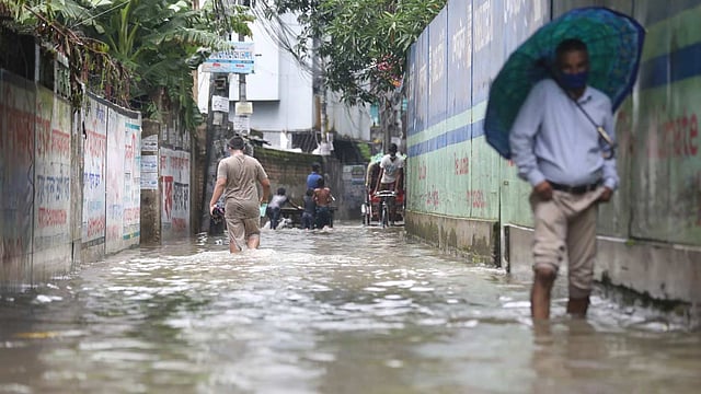 সড়কে জমা নোংরা পানি ভেঙে যাচ্ছে লোকজন। নয়াটোলা, ঢাকা, ২০ জুলাই। ছবি: আবদুস সালাম