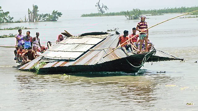 যমুনার ভাঙনে হুমকিতে ঘরবাড়ি। তাই বসতঘর ভেঙে নৌকায় তুলে বাঁধের ওপর সরিয়ে নিচ্ছেন গ্রামবাসী। গত শনিবার বিকেলে বগুড়ার সারিয়াকান্দি উপজেলার আউচার পাড়া এলাকায়। ছবি: সোয়েল রানা