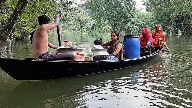 মানিকগঞ্জে অভ্যন্তরীণ নদীগুলোতে অস্বাভাবিকভাবে পানি বাড়ছে। এতে ঘরে পানি ওঠায় মালামাল নিয়ে অন্যত্র যাচ্ছে একটি পরিবার। মঙ্গলবার দুপুরে সদর উপজেলার নতুন বসতি গ্রামে। ছবি: প্রথম আলো।