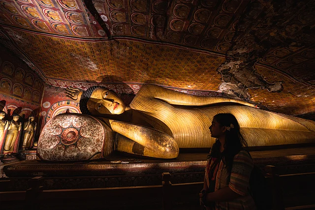 ডাম্বুলা কেভ মন্দিরের ভেতরের শায়িত বুদ্ধের সামনে শিখা