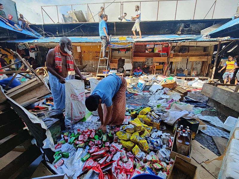 অক্ষত পণ্যগুলো সংগ্রহ করছেন দোকানিরা।