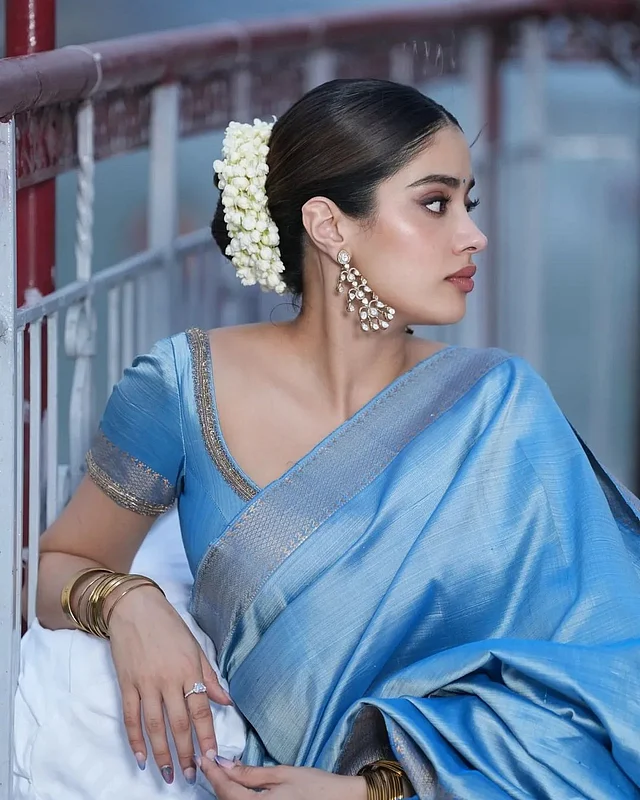 ব্লাউজের বর্ডারে অ্যান্টিক গোল্ডেন। কানে লম্বা ঝোলানো দুল। মাথায় সাদা ফুলের গাজরাইয় মোহনীয় লাগছেন শ্রীদেবী কন্যা