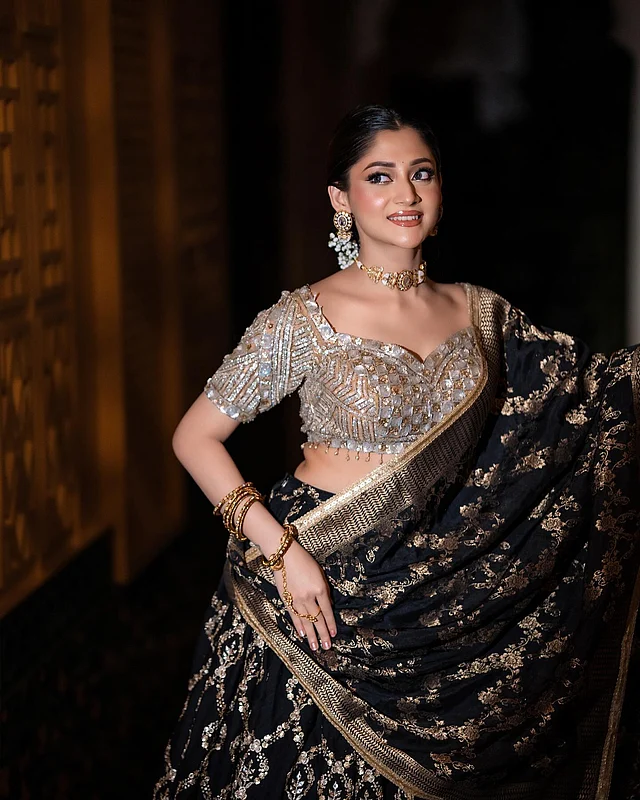 জমকালো সোনালি কাজ করা কালো লেহেঙ্গা, ঝলমলে সোনালি কারুকাজের চোলি আর সোনালি কাজ ও বর্ডারের কালো ওড়না পরেছেন তিনি