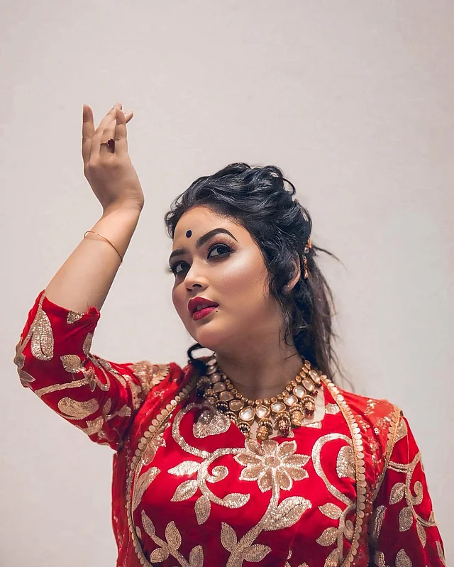 কালো টিপ, নাটকীয় আই মেকআপ আর লাল ঠোঁটে নাচের মুদ্রায় দেখা যাচ্ছে ভাবনাকে। পরনে জমকালো লাল পোশাক আর সোনালি গয়না