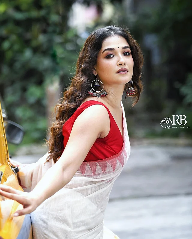 লাল-সাদার চিরন্তন আবেদন প্রকাশ পাচ্ছে এই এথনিক লুকে। লাল স্লিভলেস ব্লাউজ আর সাদা শাড়ি পরেছেন অভিনেত্রী। কাজলকালো চোখের সাজ, ছেড়ে রাখা সেমি কার্ল চুল, আর কানে শোভা পাচ্ছে নজরকাড়া ঝুমকা