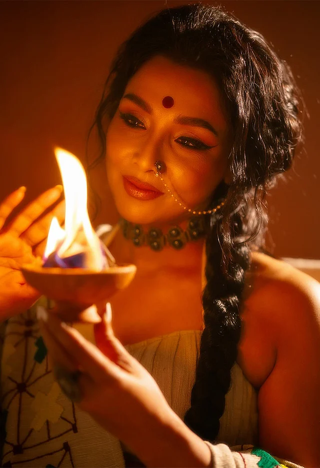 চোকার, টানা নথ আর আংটি পরেছেন রুনা। মেরুন টিপ, টেনে দেওয়া আইলাইনার আর ব্রিক রেড সেমি ম্যাট লিপকালার দেখা যাচ্ছে সাজে