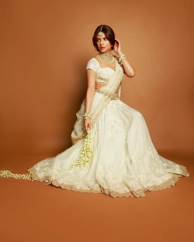 ফ্লেয়ার দেওয়া লেহেঙ্গায় ফুলেল নকশা করা গিল্ডেড লেসের বর্ডার তাতে