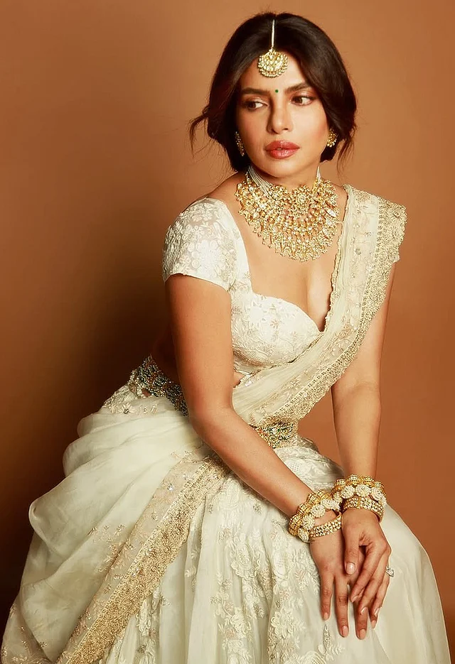 সিল্কের ওপরে অরগাঞ্জায় তৈরি ডিপনেক সুইটহার্ট চোলি আর স্কার্টের সঙ্গে ওড়নাটি শাড়ির আঁচলের মতো করেই ড্রেপ করা