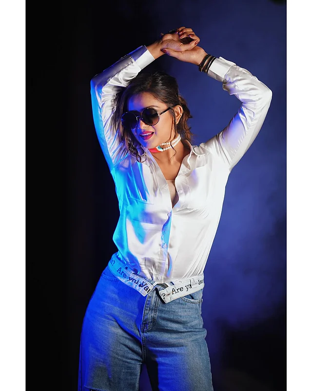 এখানে তিনি পরেছেন সাদা ফিটেড শার্ট আর ক্ল্যাসিক লাইট ব্লু হাই ওয়েস্টেড জিন্স আর শেডস