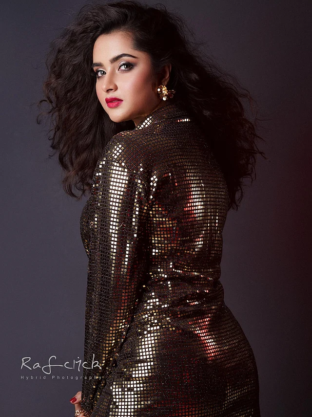 খুলে রাখা সফট কার্ল চুলগুলো ড্রামাটিক টাচ দিয়েছে এই লুকে