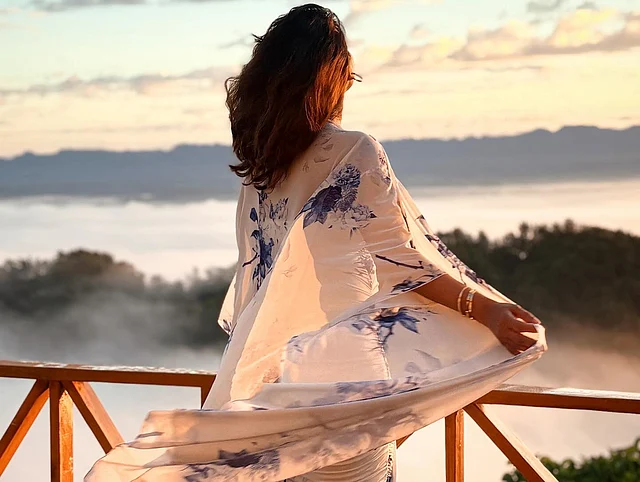 নীল প্রিন্টের ফুলেল ডিজাইনের ফ্লোয়ি ফেব্রিকের সাদা লাউঞ্জয়্যার পরেছেন তিনি