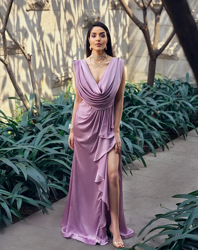 গভীর কাউল নেকলাইন, প্লিটেড ড্রেপ এবং সামনের এক পাশে নেমে আসা লেয়ারড রাফল—সব মিলিয়ে গাউনের প্রতিটি ফিচার স্নিগ্ধা সুন্দরভাবে ক্যারি করেছেন