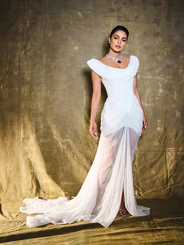প্রিয়াঙ্কা চোপড়া মানেই গ্ল্যামার আর ভরপুর আকর্ষণ। সাবেক এই ‘ব্রহ্মাণ্ডসুন্দরী’ পরেছেন শিয়ার ফেব্রিকের ফিটেড সাদা গাউন। গাউনের লম্বা ট্রেন লুকে দিয়েছে আলাদা মাত্রা।