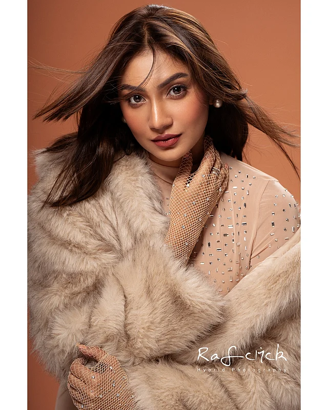 স্টোন স্টাডেড ন্যুড ড্রেস ও গ্লভসের সঙ্গে শীতের উষ্ণতাকে এক ধাপ বাড়িয়ে দিয়েছেন সুনেরাহ বিনতে কামাল। সঙ্গে নেওয়া ফো ফার জ্যাকেট লুকটিতে বিলাসবহুল ও স্টাইলিশ টাচও যোগ করেছে।