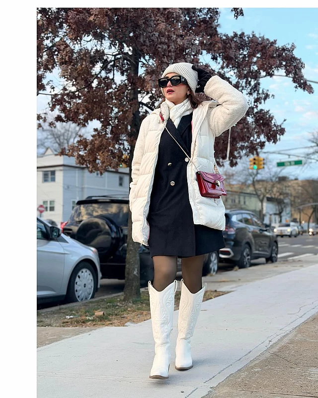 কালো ব্লেজার ড্রেসের ওপর সাদা লম্বা পাফার জ্যাকেট লেয়ারিং করে তৈরি করা হয়েছে এক আধুনিক উইন্টার-চিক লুক। কনট্রাস্টিং সাদা মাফলার আর ম্যাচিং টুপি লুকটিতে যোগ করেছে স্নিগ্ধতার ছোঁয়া। পুরো স্টাইলিংকে আরও শক্তিশালী করেছে নি-হাই বুট। ফ্যাশনে তানজিন তিশার তুলনা নেই