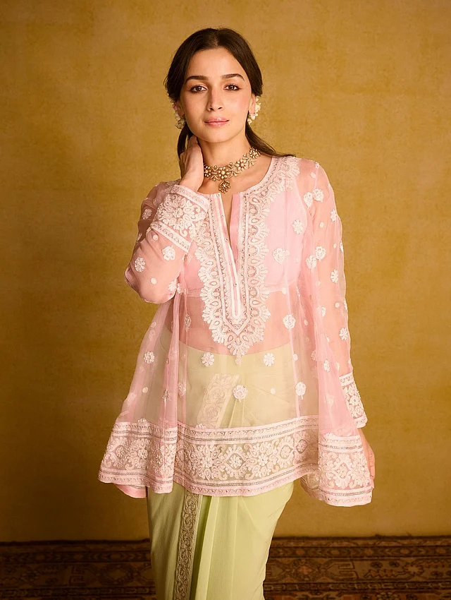 এ বছর দেওয়ালি উৎসবে আরেকটি ভিন্নধর্মী লুকে আলিয়া সবার নজরে এসেছেন। অভিনেত্রী পরেছেন প্যাস্টেল পিঙ্ক ফ্লোরাল চিকনকারি কুর্তি। এর সঙ্গে বটমে জুটি হয়েছে শিফন স্কার্ট, যা ডিজাইন করেছেন আবু জানি-সন্দীপ খোসলা। স্কার্টের ফ্লোরাল বর্ডার আর সামনের অংশের ড্রেপিং বা প্লিট শাড়ি স্টাইলে রাখা হয়েছে।