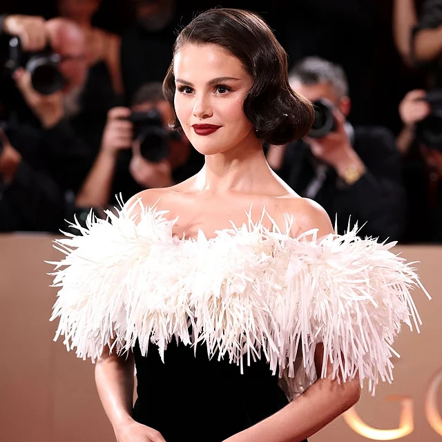 সেলেনা গোমেজের অফ দ্য শোল্ডার কালো শ্যানেল গাউনের সাদা ফার ডিটেইলিং, ওল্ড হলিউড হেয়ারস্টাইল আর লাল ঠোঁট নজর কেড়েছে সবার