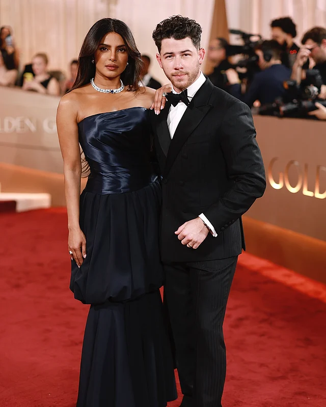 সঙ্গে এসেছেন গায়ক স্বামী নিক জোনাস কালো ডবল ব্রেস্টেড টাক্সিডো আর বো টাই পরে