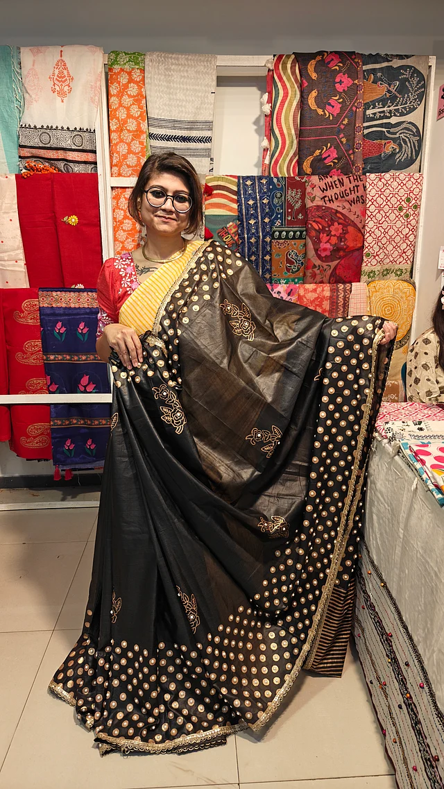 একটি একটি করে হাতে পার্ল বিডস বসানো হয়েছে গর্জিয়াস সোনালি ব্লকের কালো শাড়িতে। দেখা মিলেছে খাদি বাই নুভিয়া-র সংগ্রহে