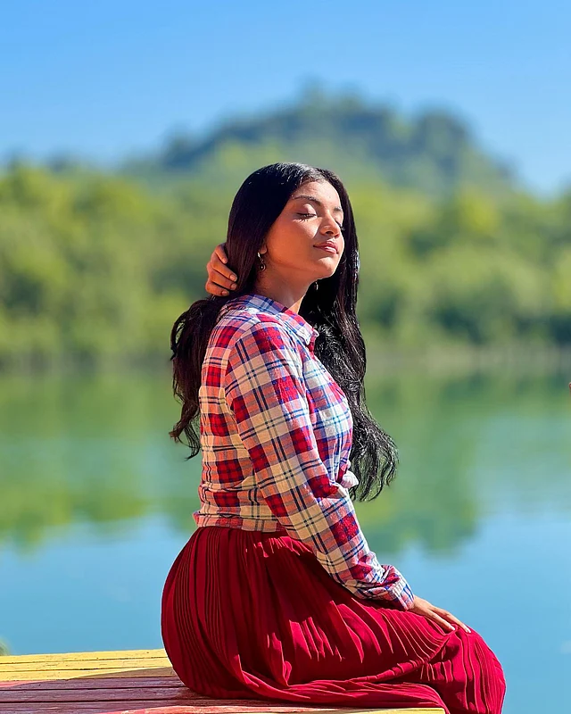 স্থির পানির মতোই শান্ত অভিব্যক্তি। এখানে তিনি পরেছেন লাল স্কার্ট আর চেকার্ড লাল-সাদা শার্ট