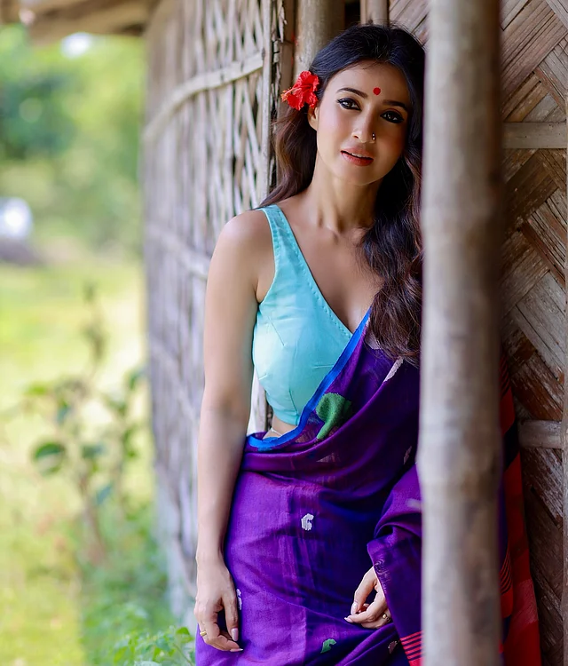 বসন্ত মানেই শুধু লাল-হলুদের ছড়াছড়ি নয়, এখন ফ্যাশনে জায়গা করে নিয়েছে নানা রঙের সাহসী মেলবন্ধন। সেই ভিন্ন আমেজেই ধরা দিলেন মনামী। আকাশি নীল স্লিভলেস ব্লাউজের সঙ্গে বেছে নিয়েছেন বেগুনি শাড়ি—যার জমিনে উঁকি দিচ্ছে আরও নানা রঙের ছোঁয়া। সফট কার্ল হেয়ারস্টাইলে কানে গোঁজা জবা ফুল যোগ করেছে দেশি ছোঁয়া। সঙ্গে নাকফুল কাজলকালো চোখ আর আবিরে রাঙানো লাল টিপে বসন্তের রং যেন আরও জীবন্ত হয়ে উঠেছে ।