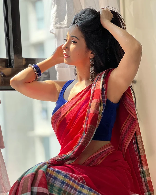 গামছা প্যাটার্নের নকশার বুননে লাল শাড়ি আর স্লিভলেস নীল ব্লাউজে মোহময়ী মনামী। অ্যাক্সেসরিজে বেছে নিয়েছেন অক্সিডাইজড গয়না—ঝুমকা, নাকফুল আর হাতে বালা। সঙ্গে রয়েছে নীল কাঁচের চুড়ি, যা পুরো লুকে এনে দিয়েছে দেশি আবহ।