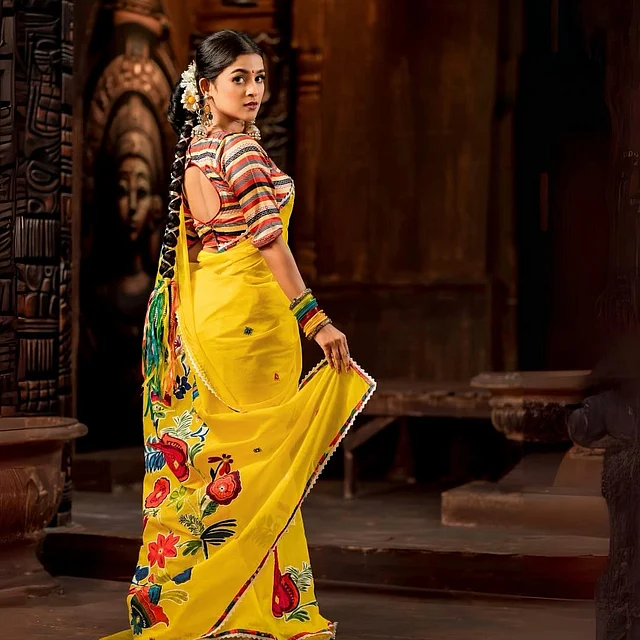 ব্যাক কাটআউট ব্লাউজের সঙ্গে আকর্ষণ কাড়ছে তাঁর হলুদ শাড়ি। জমিনে থাকা রঙিন ফুলেল মোটিফ যেন বসন্তেরই গান গাইছে। সঙ্গে ঝুমকা, চুড়ি আর লম্বা বিনুনিতে কাঁচা ফুলের সাজে বেশ সুন্দর লাগছে তাঁকে।