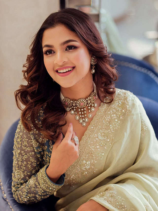 ব্লাউজের টিল বেজের ওপর ভারি গোল্ড এমব্রয়ডারির নিখুঁত কাজ অপূর্ব কনট্রাস্টে তৈরি করেছে।