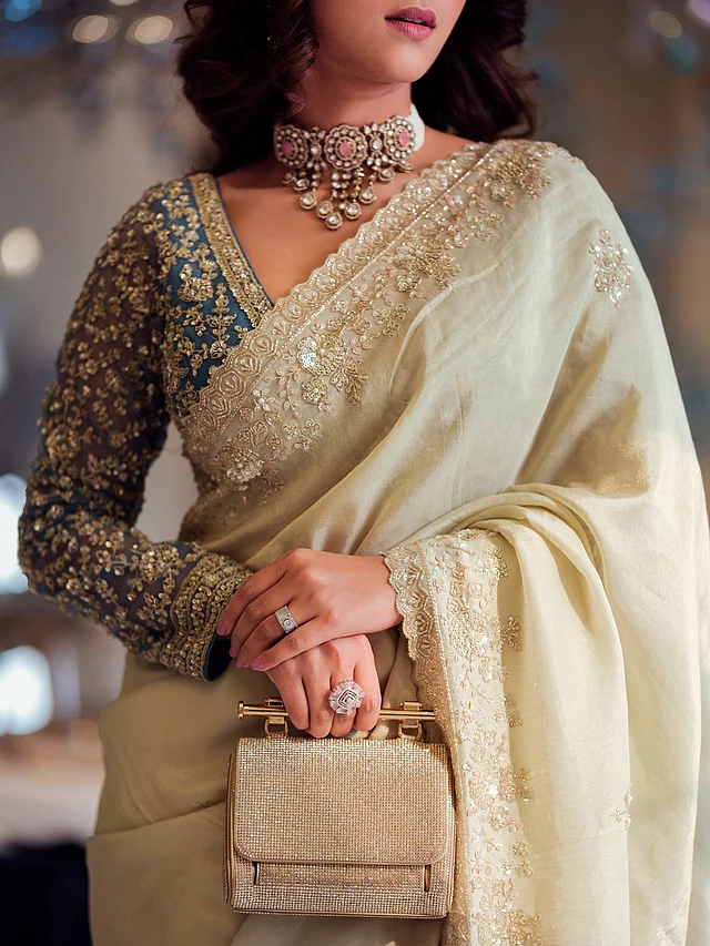 নেকলাইনের এলিগ্যান্ট কাট সাদিয়ার পরা চোকার নেকপিসকে ফুটিয়ে তুলেছে নিখুঁতভাবে। সঙ্গে নিয়েছেন গোল্ড টোনের স্ট্রাকচার্ড ক্লাচ ব্যাগ ।