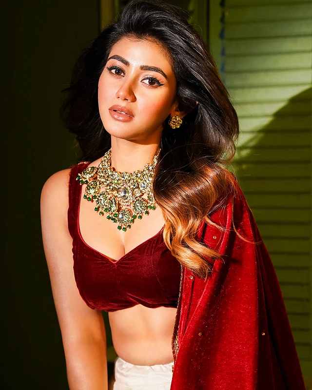লাল ভেলভেট লেহেঙ্গায় আবেদনকাড়া লুকে ফ্রেমে ধরা দিয়েছেন তিনি, গলা জুড়ে ঝলমল করছে সাদা-সবুজ স্টোনের ভারী নেকপিস