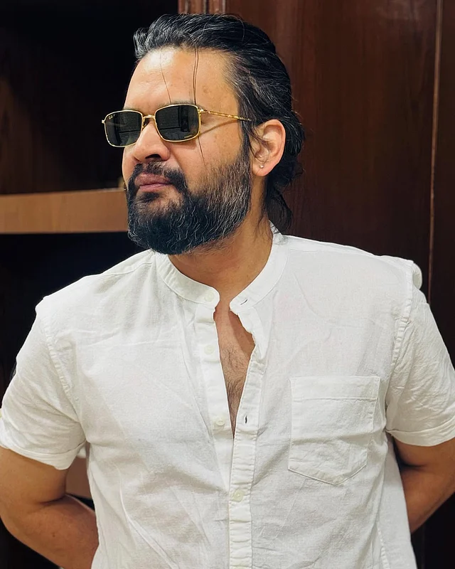 ব্যান্ড কলারের সাদা শার্টে বালেন্দ্র। সঙ্গে আছে সোনালি ফ্রেমের সানগ্লাস।