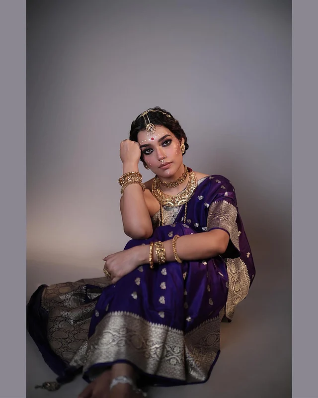 গাঢ় বেগুনি বেনারসি সিল্ক শাড়িতে সাবেকি আমেজে ধরা দিয়েছেন তিনি। অ্যান্টিক স্টাইলের সোনার জুয়েলারি পুরো সাজকে আরও রাজকীয় করেছে।