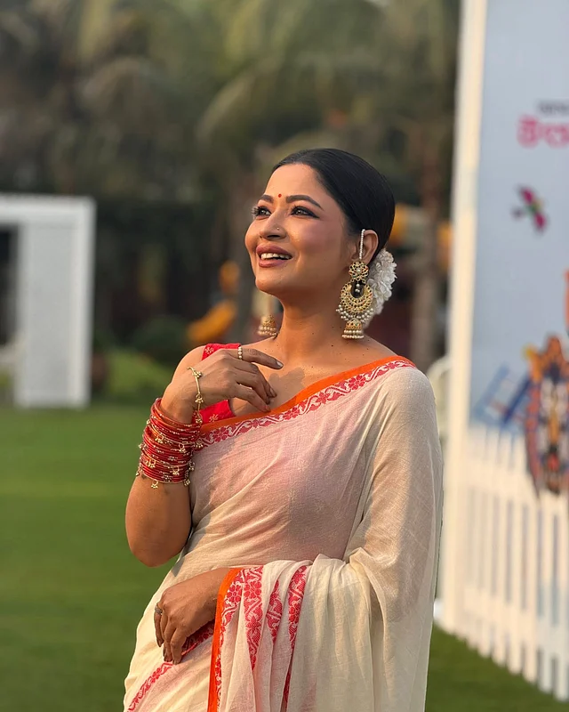 তাঁর এই সাজে অন্যতম আকর্ষণ স্টেটমেন্ট দুলে । বড় সোনালি ঝুমকা কানের দুল পরেছেন সুন্দরী। তাই নেকপিস পরেননি । এক হাত ভর্তি লাল কাঁচের চুড়ির সঙ্গে সোনালি ঝুমকা চুড়িও শোভা পাচ্ছে। গয়নাগুলো তাঁর লুককে দিয়েছে এক উৎসবমুখর পরিপূর্ণতা।