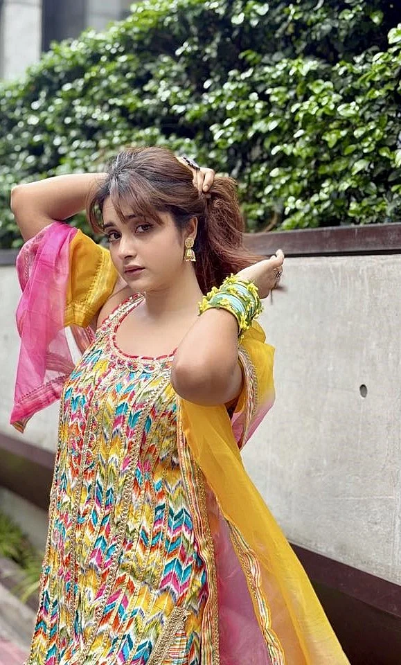 লাল-সাদার বাইরে গিয়ে হলদে-গোলাপি সংচঙে সালওয়ার কামিজ ওড়নায় কেয়া পায়েল। হাতে রঙিন কাশ্মীরি চুড়ি