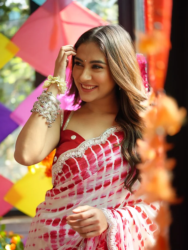 রূপালি কার্ভড বর্ডারের লাল-সাদা ডাইয়ের শাড়ি ম্যাচিং লাল সাদা সুইটহার্ট নেকলাইনের ব্লাউজ, সাদা পাথরের টিপ আর হাতভর্তি কাশ্মীরি চুড়িতে মেহজাবীন