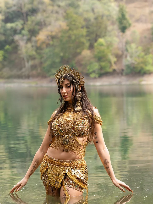 ওয়াটার গডেস লুকে নোরা পরেছেন আলাদা কাঁচুলি ও মিনিস্কার্টের আদলে গয়নায় মোড়ানো পোশাক
