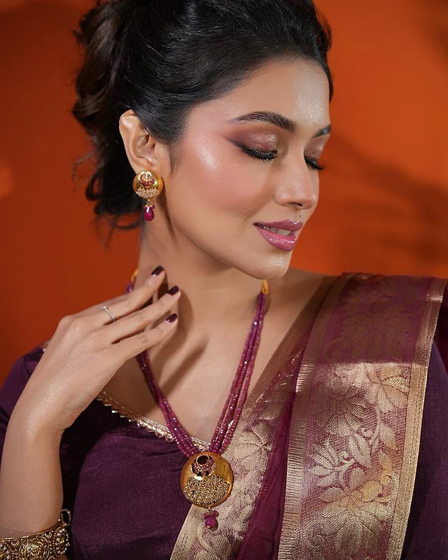 পার্পল নেইলকালার তো আছেই। সঙ্গে মানানসই আপডু। আর ম্যাচিং স্টোনের ড্রপ ইতার রিং ও বিডসে ঝোলানো পেনড্যান্ট লুকে এনেছে পূর্ণতা। হাতে চূড়ও আছে অ্যান্টিক ফিনিশের