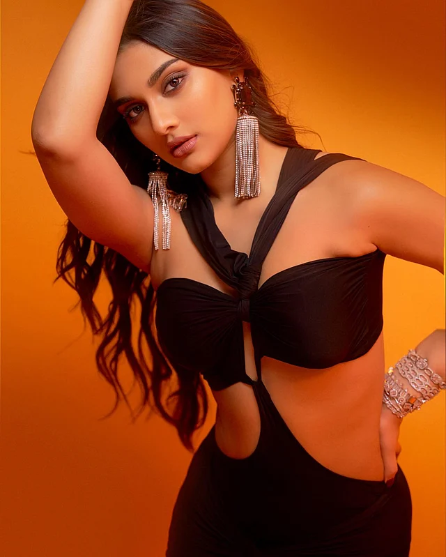 কালো এক্সট্রিম কাট আউট গাউনে সাই। কানে লম্বা সাদা পাথরের ঝোলানো দুল
