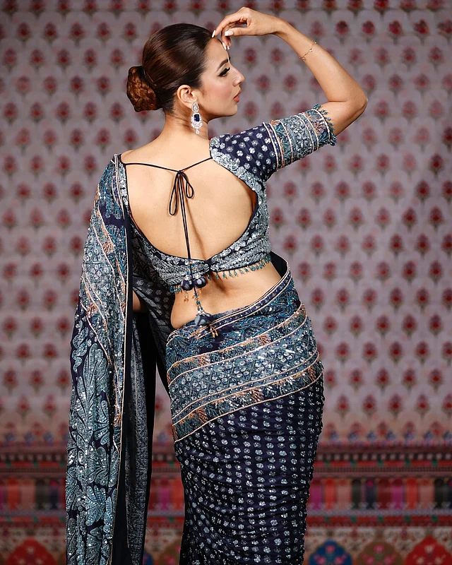 ব্যাকলেস ব্লাউজে স্ট্রিং দেওয়া। রূপালি আর আকাশি কাজ করা নেভি ব্লু শাড়ি পরা এখানে মিম