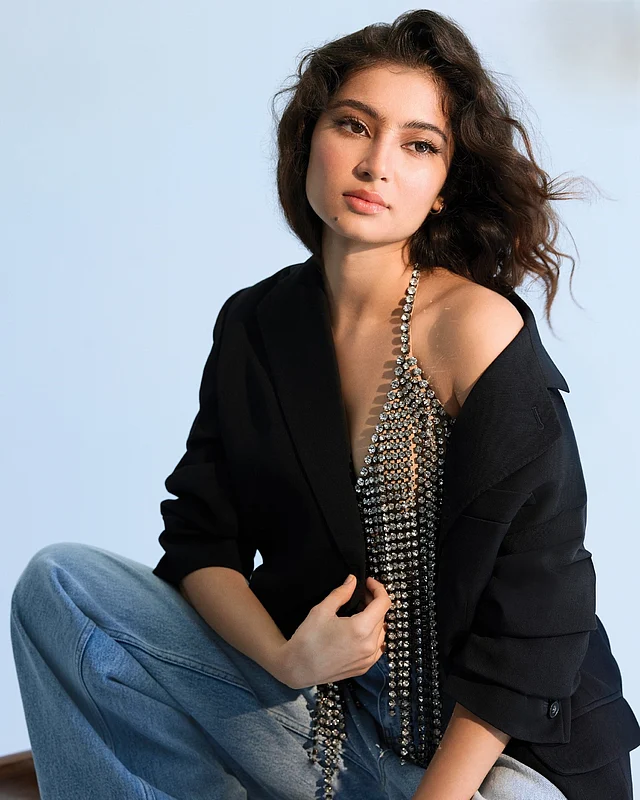 কালো ওভারসাইজড জ্যাকেট আর ফ্লেয়ার জিন্সের সঙ্গে সারা পরেছেন সাদা স্টোনের লহরের ব্রালেট